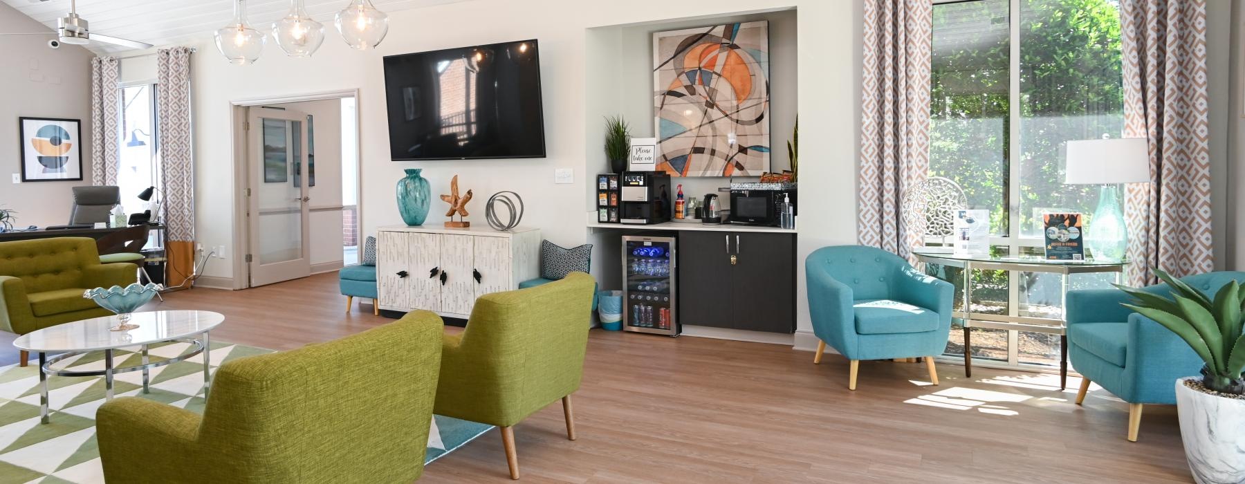 a club room with green chairs and a tv