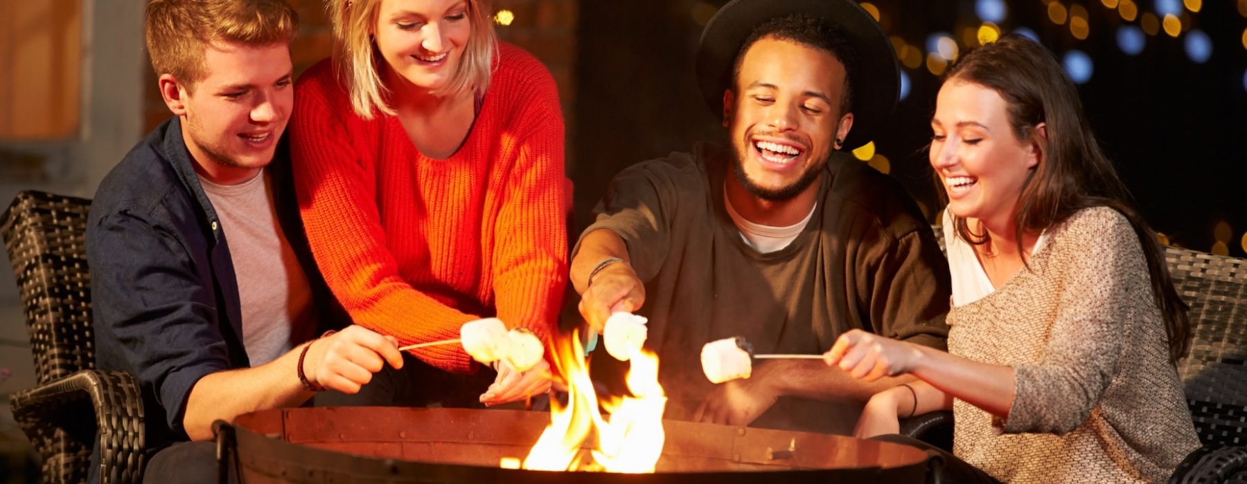 friends roasting marshmellows  by the outdoor firepit 