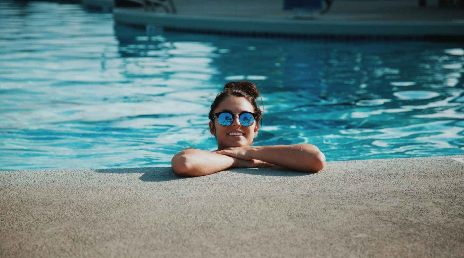 girl with her arms crossed hanging in the pool girl with her arms crossed hanging in the pool