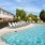 a swimming pool with chairs and a building in the background